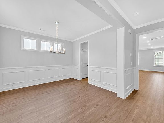 The dining room has beautiful frame molding along the walls and windows to bring in soft natural lig