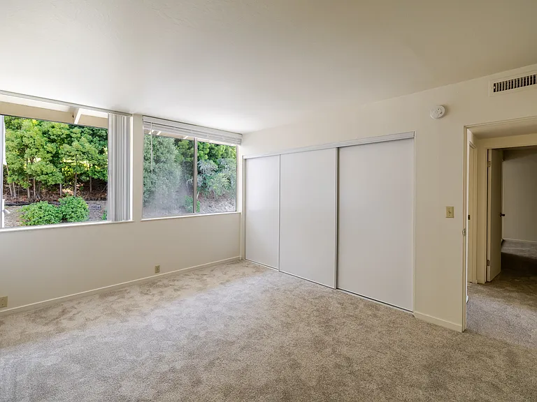 Enjoy a peaceful retreat in Bedroom B, featuring expansive windows and generous closet space.