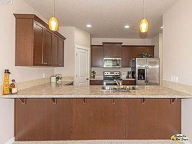 Kitchen, bar counter, looks out into living room / dining room area