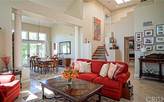 Formal living facing formal dining with elegant columns and upstairs landing with skylights