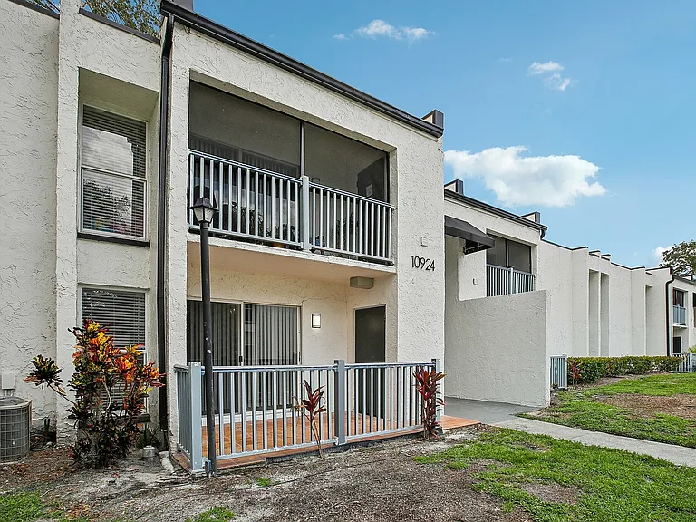 Charming apartment exterior with private balconies and lush greenery, offering modern living in a serene neighborhood.