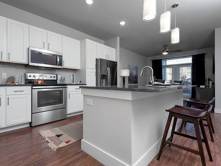 Open-concept kitchens feature Whirlpool stainless steel appliances.