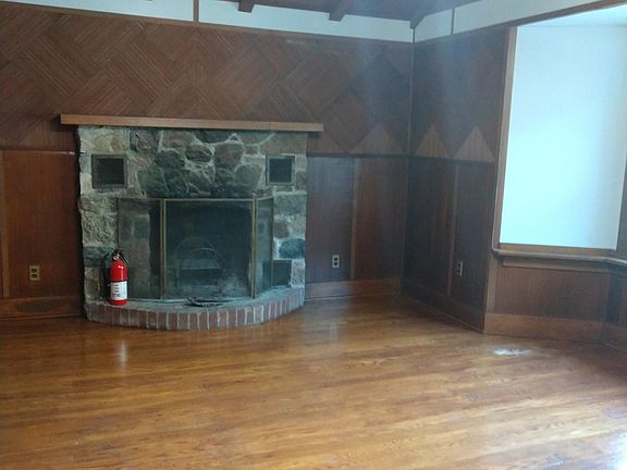 Wood burning fireplace, cathedral ceilings , wood floors, bay window with wide sills, antique lighting fixture.