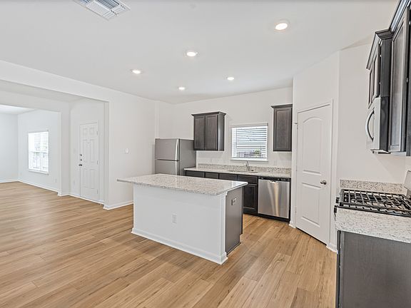 Stunning kitchen with a large island, granite countertops, and a large basin sink.