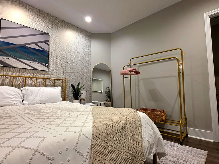 Open room with storage, seating, TV and full-length mirror