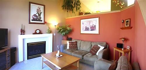 Living room adjacent to entry with large bay window and gas fireplace
