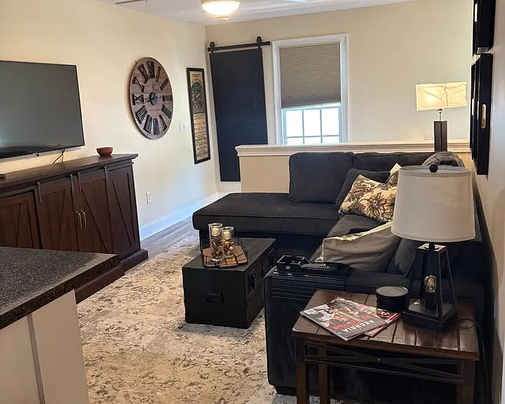 Spacious living room with queen size sleeper couch & ceiling fan.
