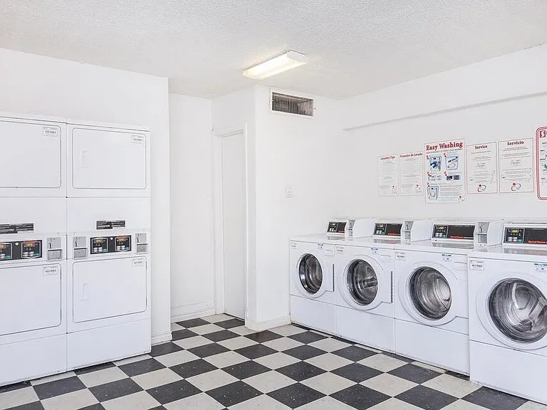 On-site laundry facility featuring multiple machines and folding areas for your convenience.