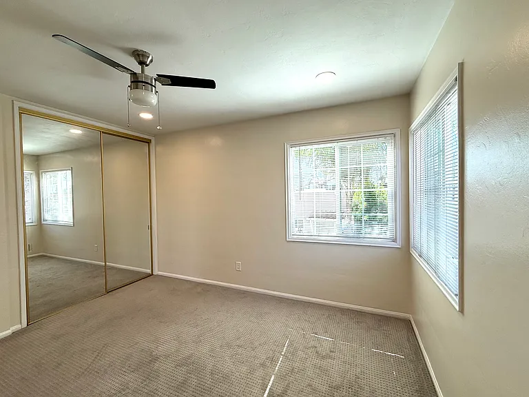 Bedroom with corner windows and ceiling fan for great natural light and breezes. New recessed lighting.