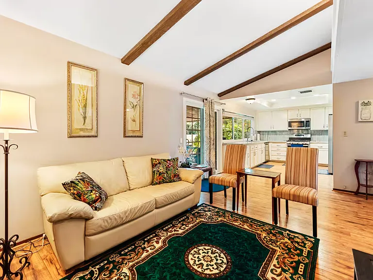 This family room has a sliding door on the left side which leads to the covered patio and backyard. That is the kitchen adjacent to this room.