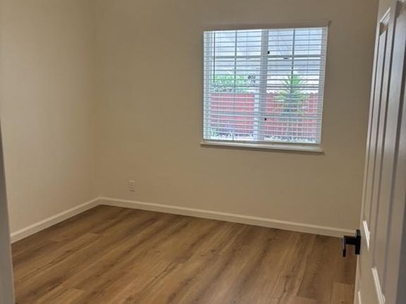One view of Bedroom #2, entirely renovated with all new flooring, paint, window covering, doors and light features.