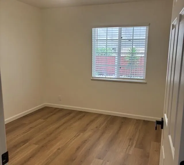 One view of Bedroom #2, entirely renovated with all new flooring, paint, window covering, doors and light features.