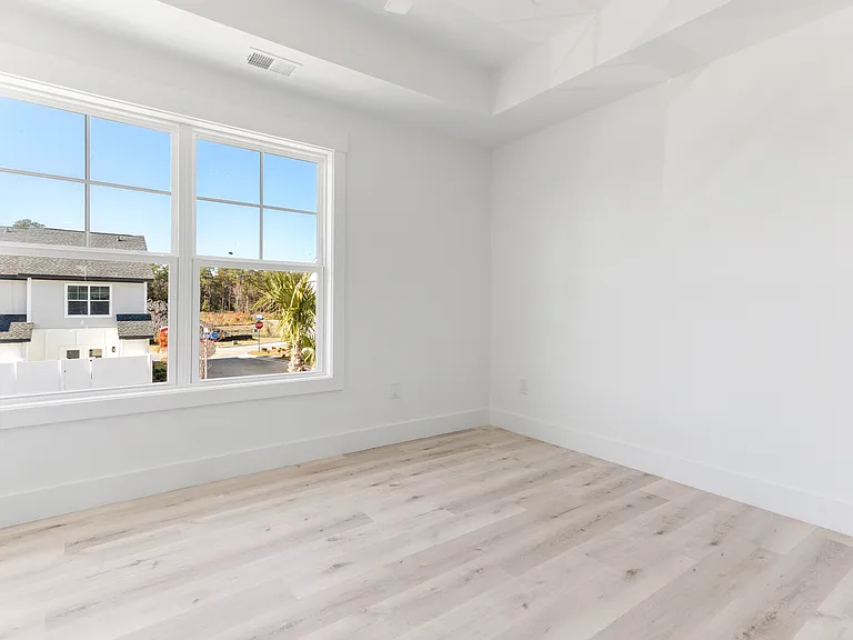 Bedroom One with bright light. Blinds will be included and are two-inch faux wood blinds.