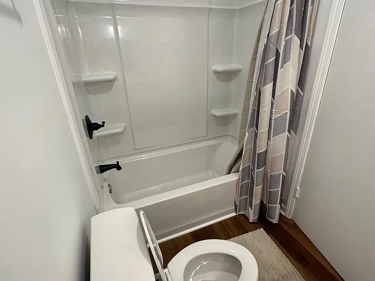Full bathroom with a tub/shower combo, built-in shelving, and updated fixtures for convenient daily use.