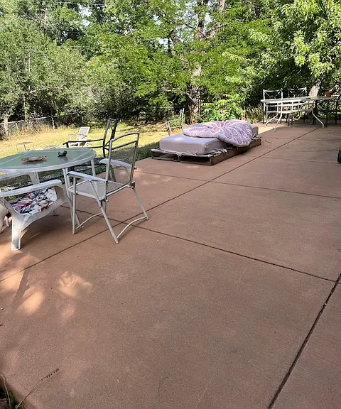 Large backyard with poured concrete patio.