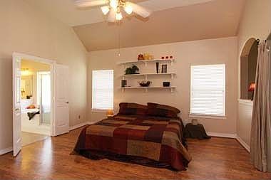 Spacious Master Bedroom with high ceilings and laminate wood floors.