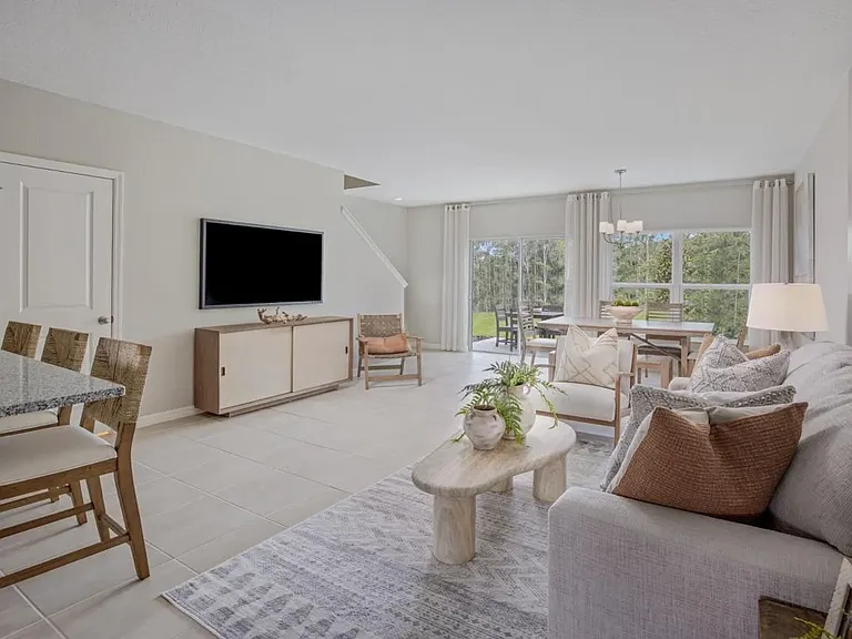 Bright open-concept living and dining area with tile flooring, large windows, and seamless flow to the kitchen_ideal for everyday living and entertaining.