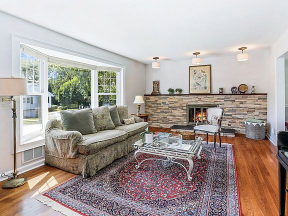 Large living room w/ picture window, a room full of sunlight and a gas fireplace