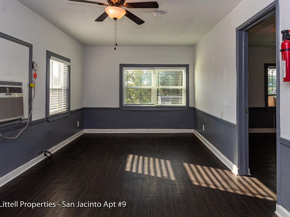 Living area with dark wood flooring, large windows with lots of sunlight. A?C unit heat & cool