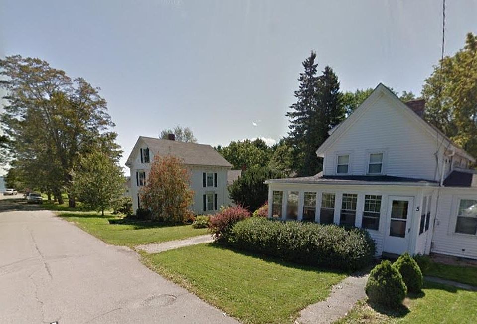 View of house looking down the street. Ocean visible at end of street.