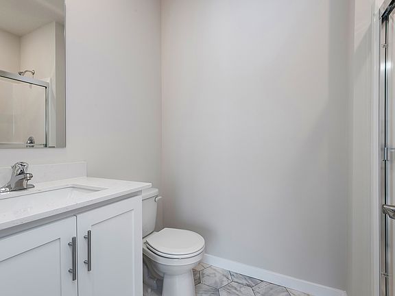 The master bathroom has a step in shower and vanity.