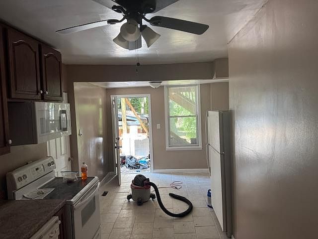 Looking from the huge Living Room is a partial view of kitchen (on left), bathroom is behind the fridge, dining area is in the back, back door leads to deck, yard and rear parking.