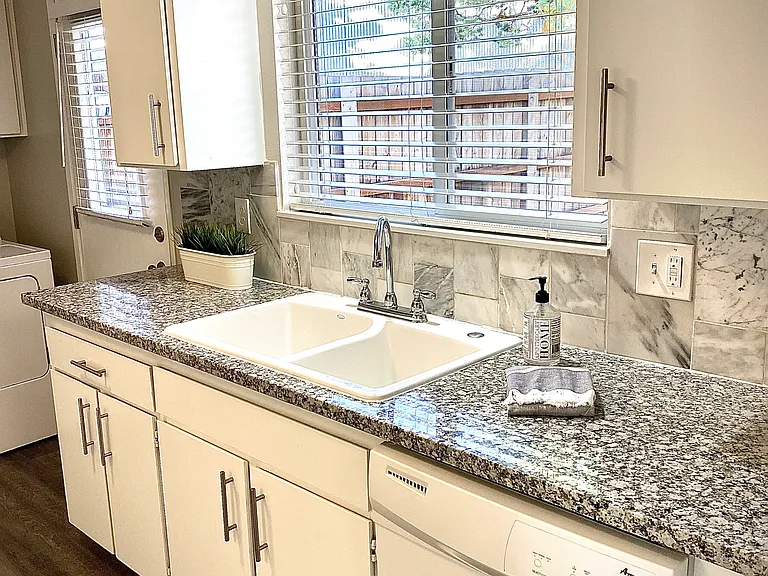 Kitchen with dishwasher & granite counters and rear entry door to backyard