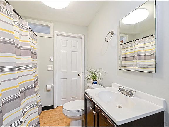 Clean, bright bathroom with full tub and shower.