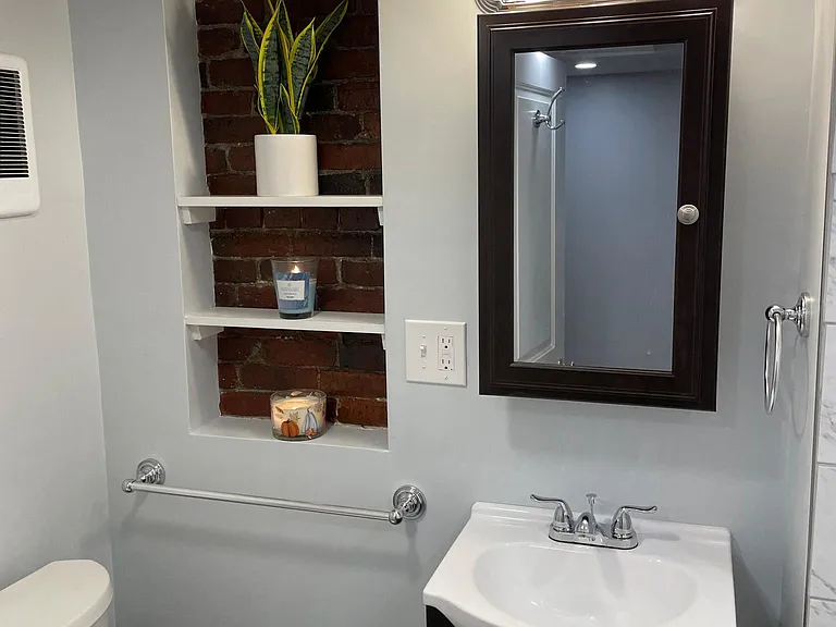 New bathroom includes exposed brick and lots of lighting.
