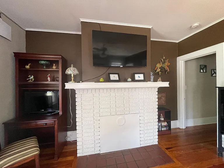 Living room includes a desk with monitor and a Smart Roku TV.