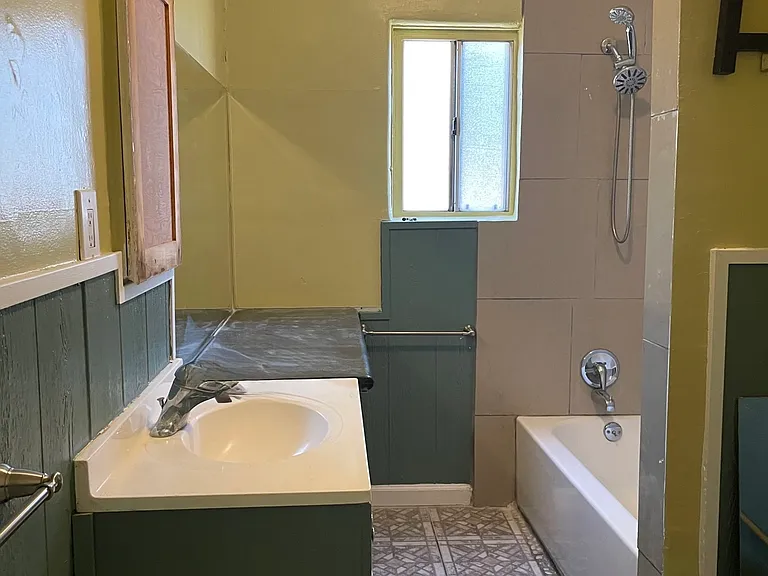 Full bathroom at end of hallway, view from doorway.