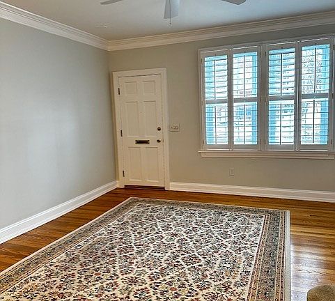 Light filled LR w/crown molding & plantation shutters.