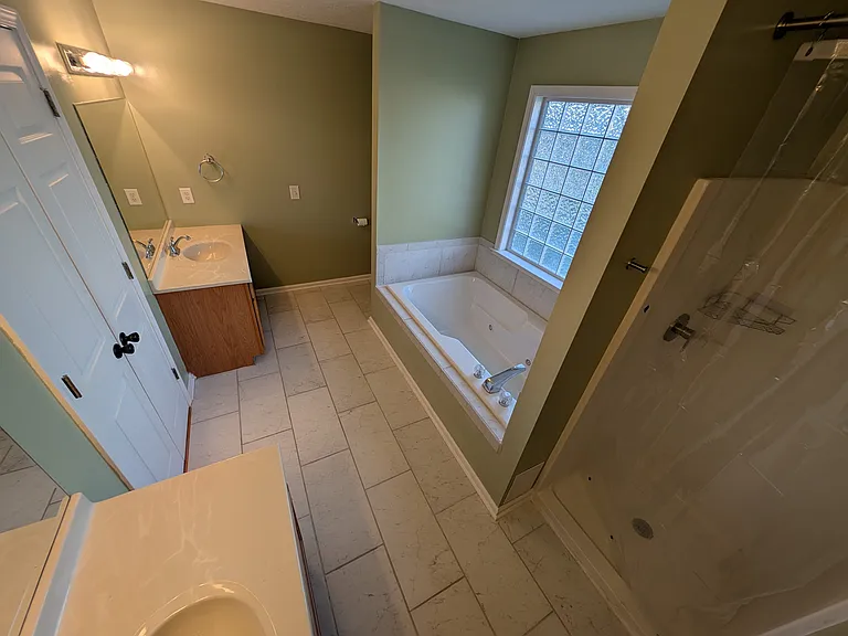 Primary Bathroom with double vanity, separate shower and large bathtub