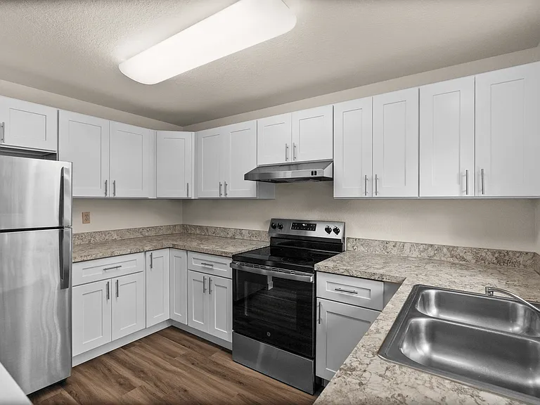 Cook in style with this updated kitchen featuring sleek stainless steel appliances, spacious white cabinetry, and elegant marble-look countertops. Cook in style with this updated kitchen featuring sleek stainless steel appliances, spacious white cabinetry