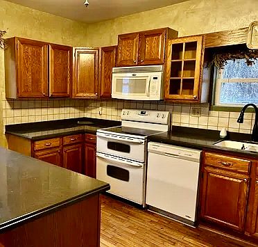 Large eat-in kitchen with hardwood floor, double oven stove, microwave, ice maker.