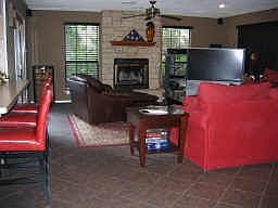 View of the den from the dining room. Tile floors cover the den and kitchen, the breakfast bar is to