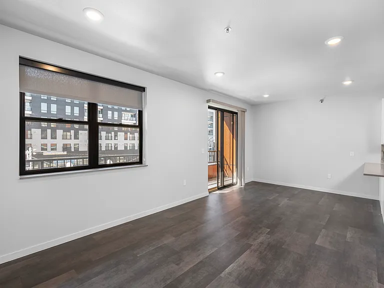 Modern apartment living room with open floor plan, large windows, and balcony access, offering ample natural light and elegant flooring. Modern apartment living room with open floor plan, large windows, and balcony access, offering ample natural light and