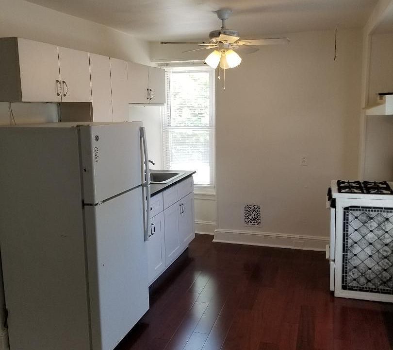 Eat-in kitchen with hardwood flooring, gas range and two-large windows.