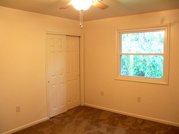 spacious bedroom with fresh carpet and ceiling fan with a scenic view!