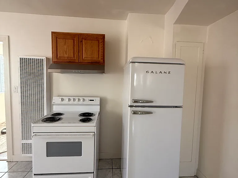 New Fridge with cabinets to the right and electric stove to the left