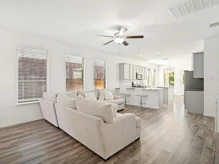 Open-concept living space featuring wood-finish flooring, recessed lighting, and a ceiling fan