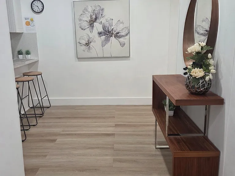 Open eat-in kitchen nook with bar seating, durable flooring, and a welcoming entry area with display console and mirror.