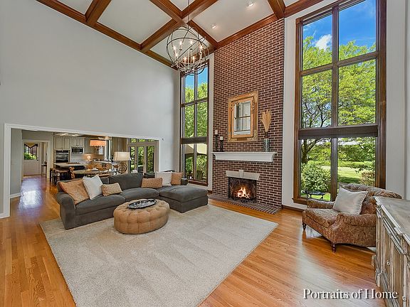 2 Story Family Rm w/coiffured ceiling, 2 story masonry fireplace, wall of New Low E windows frame lovely views of backyard, golf course & ponds.