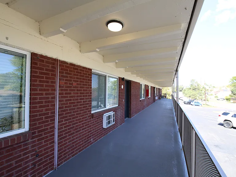 Inviting balcony with red brick exterior offering charming street views and abundant natural light, perfect for relaxation.