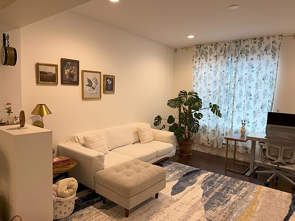 West-facing Living room with large windows and an electric fireplace.