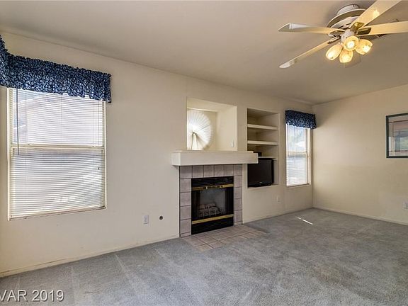 Family room with fireplace, ceiling fan and sliding doors to the backyard...