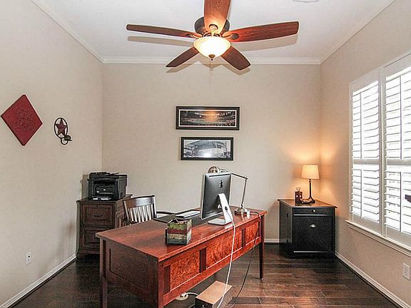The study is located to the right of the door and features French doors, wood floors, crown molding 