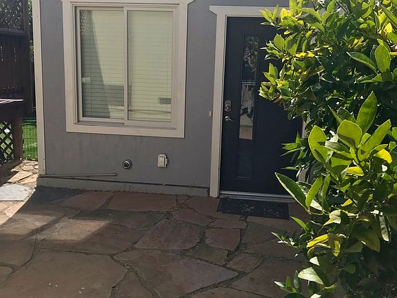 Front view of cottage, private courtyard upfront with lemon tree