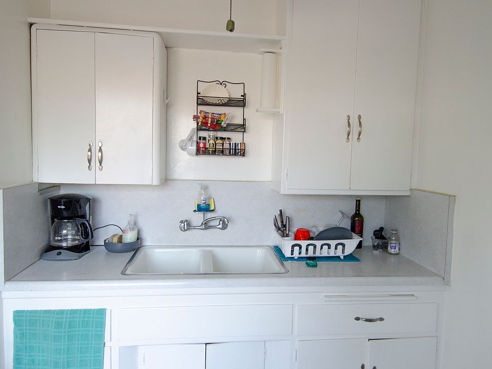 Many kitchen cabinets, ceiling fan, more storage above the refrigerator.