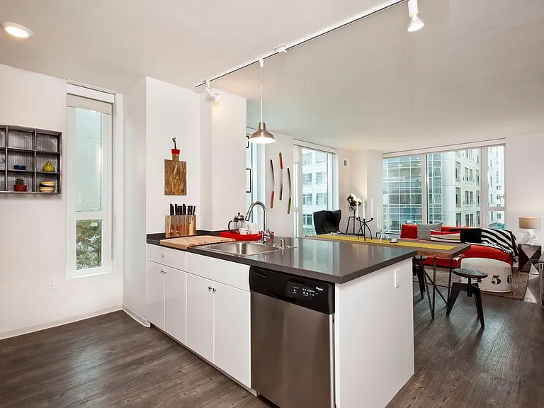 Kitchen with white cabinetry, stainless steel appliances, chrome countertops and hard surface flooring